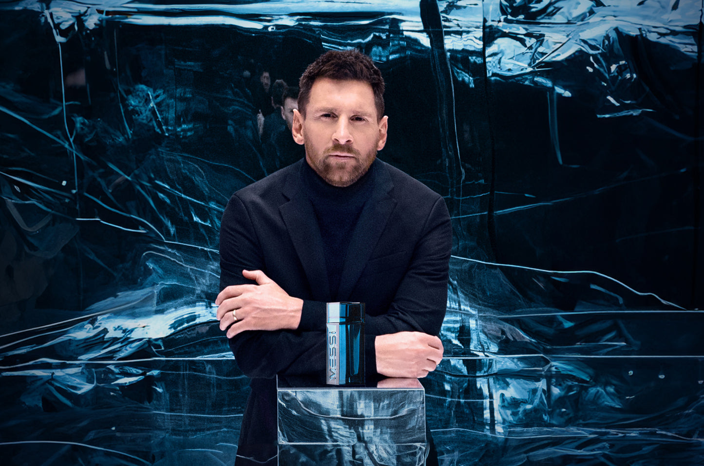 Lionel Messi standing behind a Messi Eau de Parfum bottle, leaning on a reflective surface with a dark, abstract backdrop.